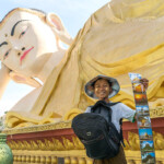 Junge verkauft Postkarten vor dem riesigen liegenden Myatharlyaung Buddha in Bago, Myanmar , Asien | boy selling postcards at the giant Myatharlyaung Reclining Buddha Image in Bago, Myanmar, Asia