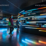 Besucherin mit Maske in der Ausstellung im Innenraum des Museum für Fragen der Zukunft Futurium in Berlin, Deutschland | visitor with mask watching the exhibition inside the museum and House of Futures Futurium in Berlin, Germany