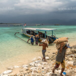 Arbeiter bringen Baumaterial vom Boot auf die kleine Insel Gili Meno vor Lombok, Indonesien, Asien | workers carrying construction materials to the small island Gili Meno, Lombok, Indonesia, Asia