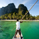 Bootsmann im typischen Auslegerboot bei der Anfahrt auf Inabuyutan Island im Bacuit Archipel, El Nido, Palawan, Philippinen, Asien | Boatsman in a traditional outrigger boat approaching Inabuyutan Island, Bacuit Archipelago, El Nido, Palawan, Philippines, Asia