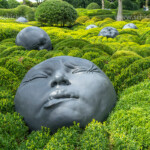 Riesige Gesichter im Garten der Emotionen Jardin Émotions, die Gärten von Etretat - Les Jardins d'Etretat, Etretat, Normandie, Frankreich | large faces depicting human emotions in the Garden of Emotions, Jardin Émotions, The Etretat Gardens - Les Jardins d'Etretat, Etretat, Normandy, France