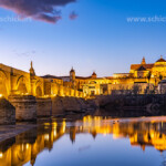 Römische Brücke über den Fluss Río Guadalquivir und die Mezquita - Catedral de Córdoba in der Abenddämmerung, Cordoba, Andalusien, Spanien | Roman bridge over Río Guadalquivir river and the Mezquita - Mosque–Cathedral of Córdoba at dusk, Andalusia, Spain