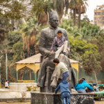 Kinder klettern auf der Statue des Dichters Hafez Ibrahim im Park Al Horreya Garden in Kairo, Ägypten, Afrika | Children climbing the statue of Egyptian poet Hafez Ibrahim, Al Horreya Garden in Cairo, Egypt, Africa